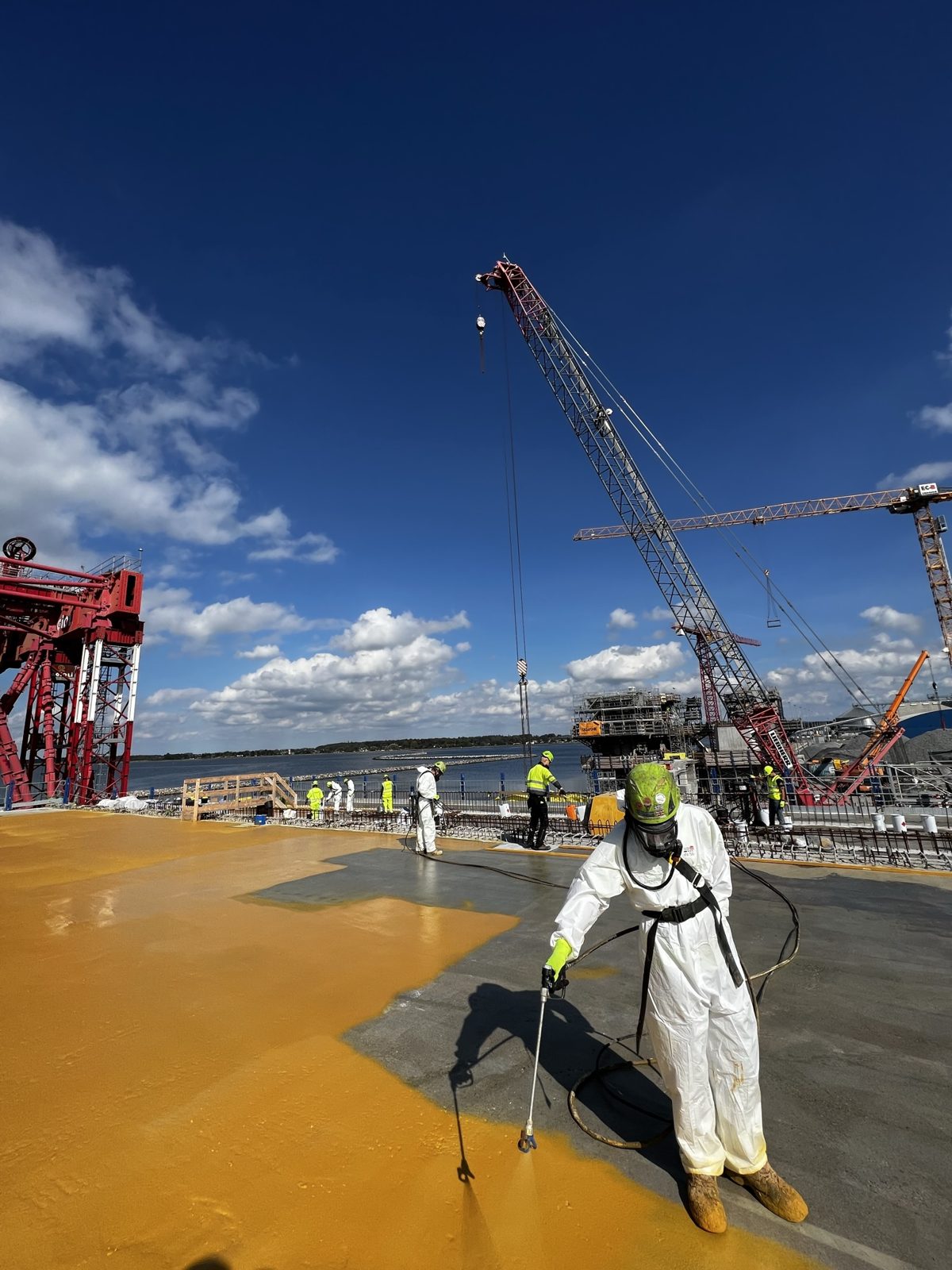 Spray application of yellow membrane on a bridge girder on land at Masnedø, September 2023