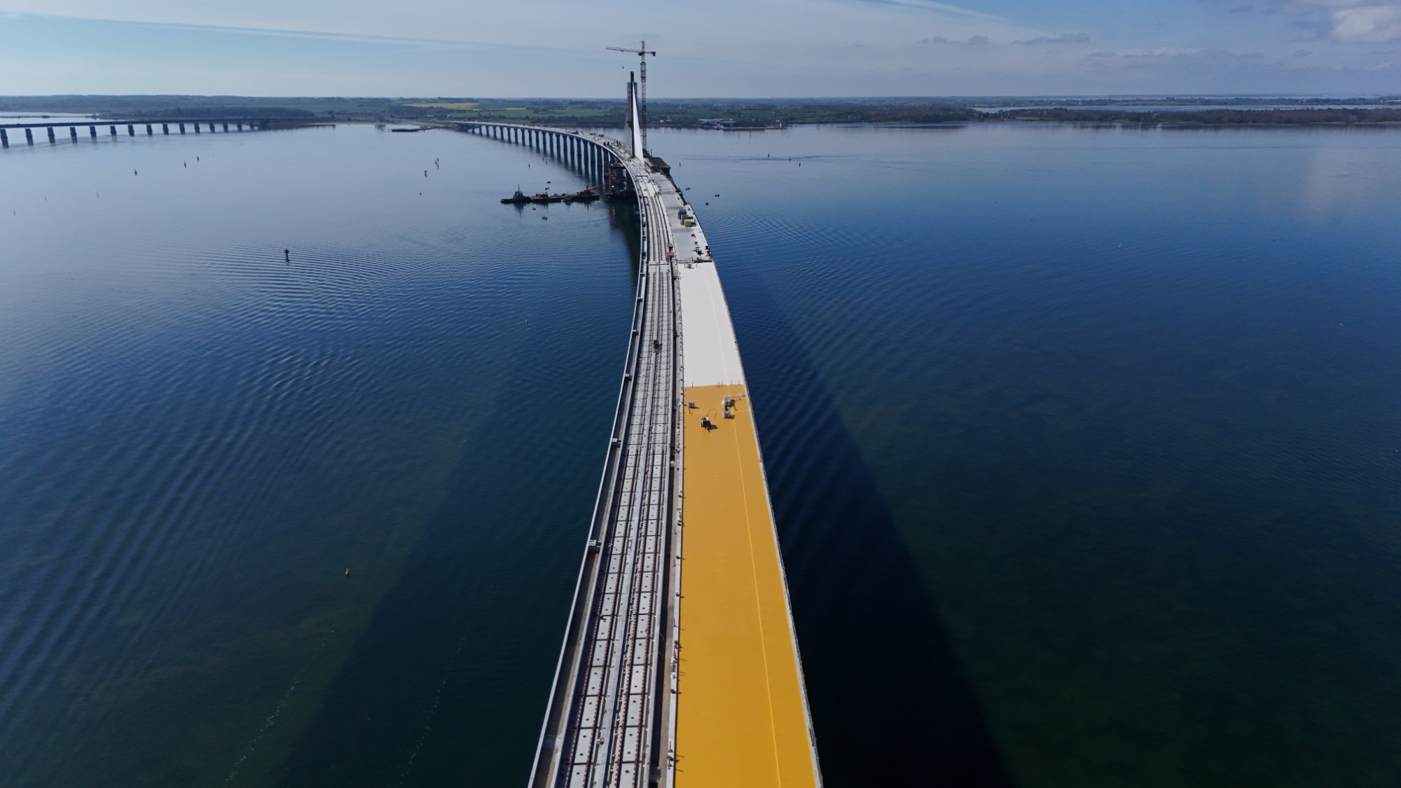 KBT-applikatorer sprøjter hvidt Type 5 topcoat over gult basecoat på Storstrømsbroen under verificerede klimaforhold