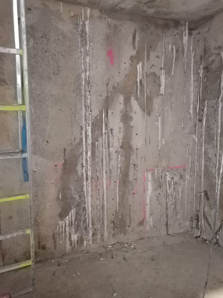Kældervæg med massiv fugtindtrængning og kalkudfældninger