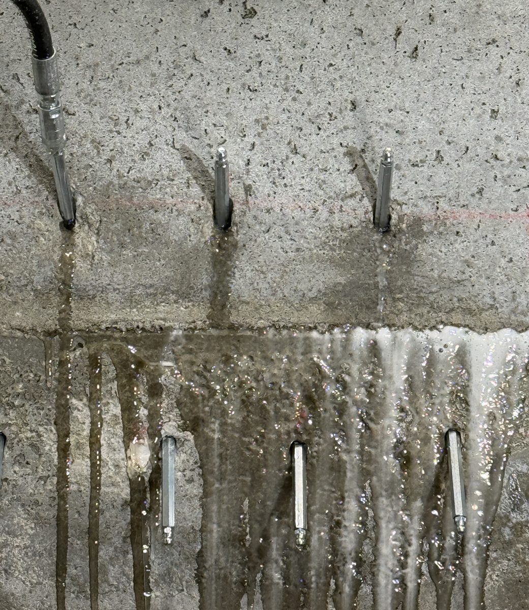 Vand strømmer aktivt gennem støbeskel i betonvæg